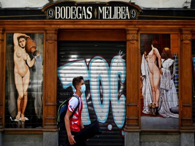 Un jeune homme passe devant un bar fermé à Madrid, en Espagne, le 9 juillet 2020 - Gabriel BOUYS [AFP/Archives]
