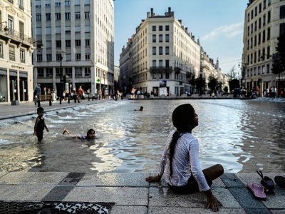 Un enfant se rafraichit à Lyon, le 30 juillet 2020 - JEFF PACHOUD [AFP]
