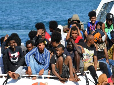 Des migrants en provenance de Tunisie et de Libye arrivent à Lampedusa à bord d'un bateau des gardes-côtes italiens, le 1er août 2020 - Alberto PIZZOLI [AFP]