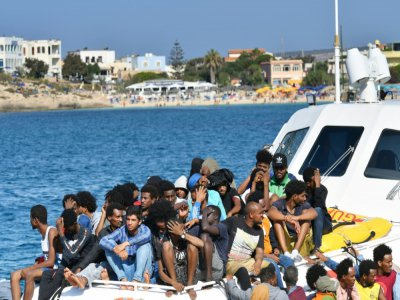 Des migrants en provenance de Tunisie et de Libye arrivent à Lampedusa à bord d'un bateau des gardes-côtes italiens, le 1er août 2020 - Alberto PIZZOLI [AFP]