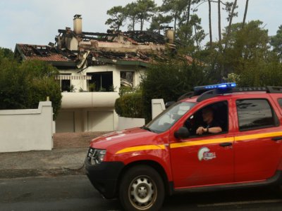 Des pompiers surveillent une maison détruite dans l'incendie de la forêt de Chiberta, le 31 juillet 2020 à Anglet, dans les Pyrénées-Atlantiques - GAIZKA IROZ [AFP]