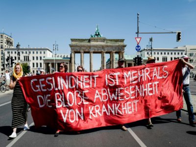 Des manifestants participent à la marche contre les mesures contraignantes liées au Covid-19, le 1er août à Berlin - John MACDOUGALL [AFP]