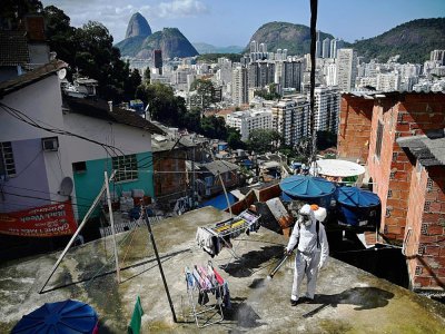 Désinfection d'un toit dans une favela de Rio de Janeiro le 1er août 2020 - CARL DE SOUZA [AFP]