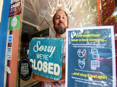 Gabriel Gordon derrière la porte de son restaurant qu'il doit fermer définitivement en raison de la pandémie, le 28 juillet 2020 à Seal Beach, en Californie - Frederic J. BROWN [AFP]