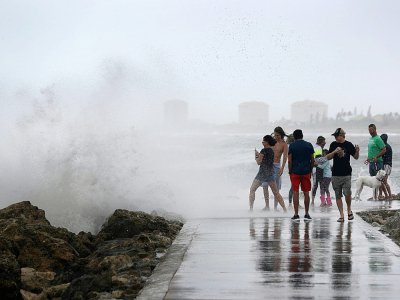 Un groupe de personnes s'amuse avec les vagues de la tempête tropicale Isaias à Fort Pierce (Floride), le 2 août 2020 - JOE RAEDLE [GETTY IMAGES NORTH AMERICA/AFP]