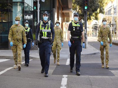 Des policiers et des soldats en patrouille à Melbourne (Australie) le 2 août 2020 après l'instauration d'un couvre-feu en raison du coronavirus - William WEST [AFP]