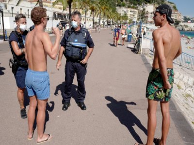 Des policiers patrouillent le long de la promenade des Anglais à Nice le 3 août 2020 pour informer les passants du port du masque obligatoire - VALERY HACHE [AFP]
