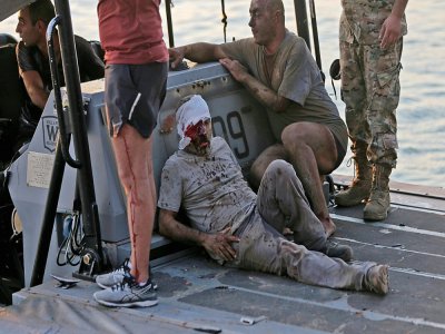 Un blessé évacué par bateau après deux puissantes explosions à Beyrouth, le 4 août 2020 au Liban - STR [AFP]