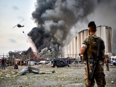Des soldats libanais devant un hélicoptère tentant d'éteindre l'incendie provoqué par deux explosions sur le port de Beyrouth, au Liban le 4 août 2020 - STR [AFP]