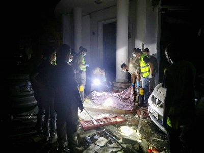 Des secouristes libanais couvrent le corps d'un homme tué par l'explosion du port de Beyrouth le 4 août 2020 - PATRICK BAZ [AFP]
