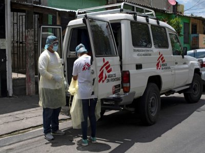 Des membres de Médecins sans Frontières s'apprêtent à s'occuper d'un patient soupçonné d'être contaminée par le Covid-19, dans un quartier de Ilopango, le 30 juillet 2020 - Yuri CORTEZ [AFP]