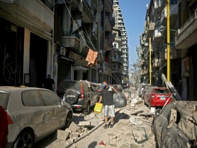 Un homme ramasse ses affaires dans le quartier de Mar Mikhaël le 5 août 2020, le "coeur battant" de Beyrouth dévasté par les explosions de la veille - PATRICK BAZ [AFP]