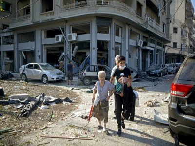 Une femme est évacuée du quartier de Mar Mikhaël, le 5 août 2020, le "coeur battant" de Beyrouth dévasté par les explosions de la veille - PATRICK BAZ [AFP]