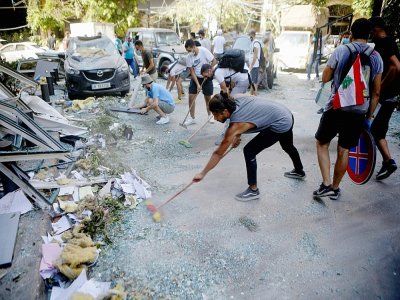 Des bénévoles libanais nettoient les rues de la capitale libanaise Beyrouth après les explosions au port, le 5 août 2020 - PATRICK BAZ [AFP]