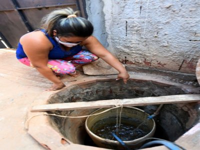 Poliana Feitosa montre le réservoir d'eau potable de sa maison à Santa Luzia, près de Brasilia, le 3 août 2020 - EVARISTO SA [AFP]