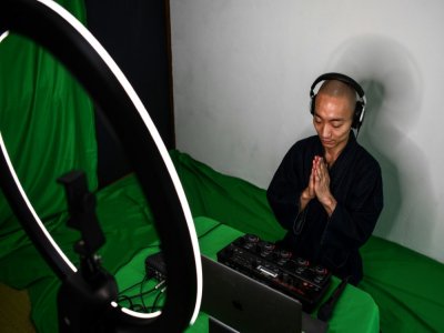 Le moine bouddhiste et musicien beatbox Yogetsu Akasaka prie, le 26 juin 2020 à son domicile à Tokyo - CHARLY TRIBALLEAU [AFP]