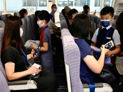 Des enfants et leurs parents jouent les rôles de personnel de cabine et de passagers au siège de China Airlines, à Taoyuan (Taïwan) le 8 août 2020 - Sam Yeh [AFP]