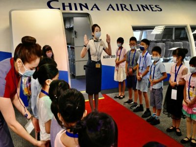 Du personnel navigant de China Airlines fait découvrir son métier à des enfants à Taoyuan (Taïwan), le 8 août 2020 - Sam Yeh [AFP]