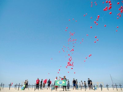 Lâcher de ballons sur la plage de Copacabana de Rio en hommage aux plus de 100.000 morts du Covid-19 au Brésil, le 8 août 2020 - Mauro Pimentel [AFP]