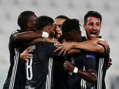 Des joueurs de l'Olympique lyonnais félicitent Memphis Depay après son pénalty inscrit contre la Juventus Turin en 8e de finale retour de la Ligue des champions le 7 août 2020 à Turin - Miguel MEDINA [AFP/Archives]
