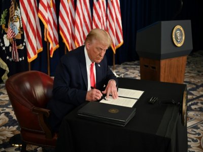 Le président américain Donald Trump signe un plan d'aide à l'économie par décret au cours d'une conférence de presse dans son club de golf de Bedminster, dans le New Jersey, le 8 août 2020 - JIM WATSON [AFP]