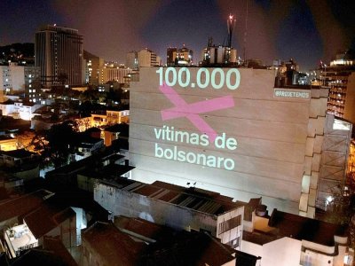 Projection lumineuse sur un mur dans un quartier de Rio de Janeiro, le 8 août 2020 du nombre de 100.000 morts "victimes de Bolsonaro" - Mauro PIMENTEL [AFP]