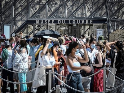 Des visiteurs devant l'entrée du Louvre le 6 août 2020 à Paris - STEPHANE DE SAKUTIN [AFP]