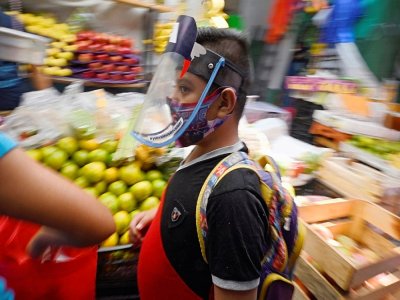 Un jeune garçon porte un masque en plexiglas au marché de San Cosme à Mexico le 10 août 2020 - Alfredo ESTRELLA [AFP]