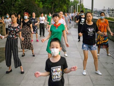 Des gens dansent dans la rue près de la rivière Yangtsé à Wuhan (Chine) le 4 août 2020 - Hector RETAMAL [AFP]