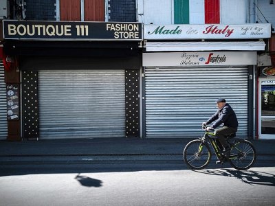 Un cycliste dans une rue déserte de Lourdes, dans le sud de la France, le 9 avril 2020 - Lionel BONAVENTURE [AFP/Archives]