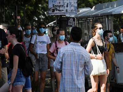 Des personnes portent des masques de protection dans une rue du quartier de Montmartre, le 11 août 2020 à Paris - ALAIN JOCARD [AFP]