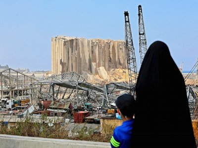 Une femme et un enfant regardent le 12 août 2020 à Beyrouth un silo à grains dévasté par les explosions - Anwar AMRO [AFP]