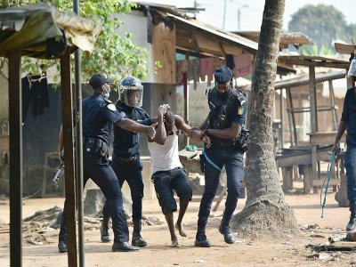 Des policiers arrêtent un manifestant dans la commune de Yopougon, à Abidjan, le 13 août 2020. - SIA KAMBOU [AFP]