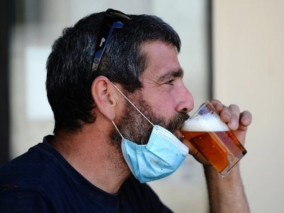 Un homme boit une bière en terrasse à Séville (Espagne) le 13 août 2020 - CRISTINA QUICLER [AFP]