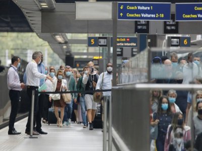 Des voyageurs, portant des masques de protection, sur un quai de la gare St Pancras de Londres, à leur descente de l'Eurostar en provenance de Paris, le 14 août 2020 - Tolga AKMEN [AFP]