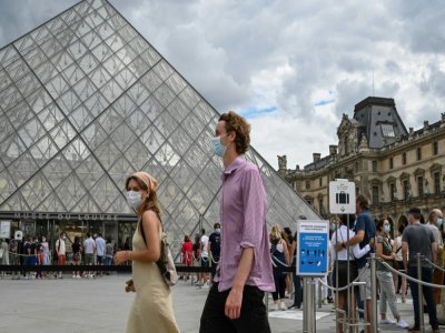 Des touristes passent devant la Pyramide du Louvre conçue par l'architecte Ieoh Ming Pei, le 15 août 2020 à Paris - BERTRAND GUAY [AFP]