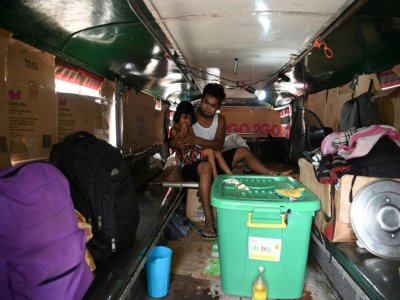 Daniel Flores, mis au chômage par le confinement et expulsé de son logement, habite avec sa famille dans sa "jeepney" qu'il ne conduit plus, le 12 août 2020 à Manille, aux Philippine - Ted ALJIBE [AFP]