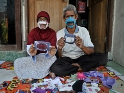 Dwi Rahayu (g) et son mari Elfiandi, tous deux sourds et muets, présentent leurs masques transparents à Yogyakarta, en Indonésie, le 22 avril 2020 - AGUNG SUPRIYANTO [AFP/Archives]