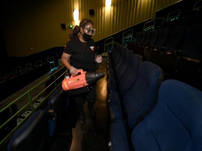 Une employée d'un cinéma de Las Vegas désinfecte des fauteuils - Ethan Miller [GETTY IMAGES NORTH AMERICA/AFP]