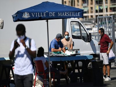 Des vendeurs de rue avec des masques de protection, le 26 août 2020 sur le vieux port à Marseille - Christophe SIMON [AFP]