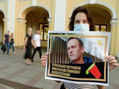 Une jeune femme tient le portrait de l'opposant russe Alexeï Navalny, le 20 août 2020 à Saint-Pétersbourg - OLGA MALTSEVA [AFP/Archives]