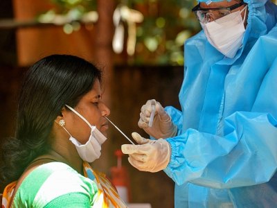Un personnel médical portant un équipement protectif teste un femme au Covid-19 le 26 août 2020 à Siliguri en Inde - DIPTENDU DUTTA [AFP]