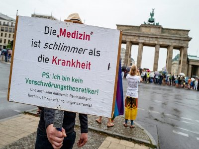 "Le remède est pire que le mal", proclame une banderole pendant une manifestation contre les mesures sanitaires, le 1er août 2020 à Berlin - John MACDOUGALL [AFP/Archives]