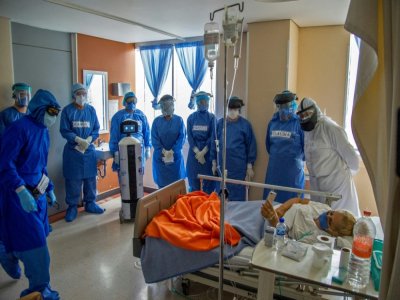 Le petit robot Laluchy avec des soignants au chevet d'une malade du Covid-19, le 27 août 2020 dans un hôpital de Mexico - CLAUDIO CRUZ [AFP]