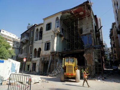 Des ouvriers enlèvent les décombres sous un bâtiment partiellement détruit par l'explosion dans le port de Beyrouth, le 26 août 2020 au Liban - JOSEPH EID [AFP]