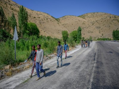 Des migrants marchent le long d'une route depuis la frontière iranienne et la ville de Tatvan, dans la région du Lac de Van, le 24 août 2020 en Turquie - BULENT KILIC [AFP]