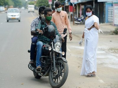 Une soignante propose un test de coronavirus à deux motards, à Chennai (Inde), le 30 août - Arun SANKAR [AFP]