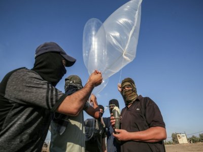 Des Palestiniens attachent un explosif à des ballons qu'ils lâchent vers Israël, le 21 août 2020 - SAID KHATIB [AFP/Archives]