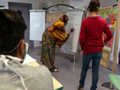 Un bénévole de l'association CeCler donne des cours de français à des réfugiés, le 26 août 2020 à Pessat-Villeneuve - Thierry ZOCCOLAN [AFP]