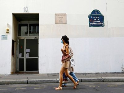 Deux personnes passent devant l'immeuble où des journalistes de Charlie Hebdo ont été assassinés en janvier 2015 par des djihadistes à Paris, le 30 août 2020 - Thomas COEX [AFP]